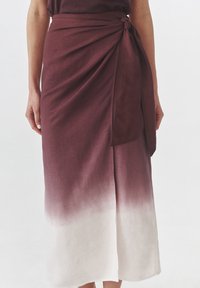 Burgundia värvi lõhkene seelik, millel on gradient fade valge. Valmistatud kerge kangaga, millel on vöökoht seotav detail. Sile tekstuur.