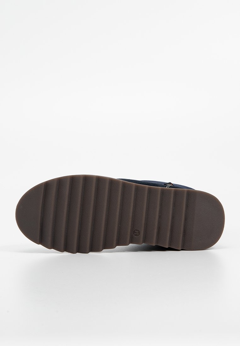 Marineblaue Schuhe mit einer Gummisohle, die horizontale Rillen für besseren Halt aufweisen und einen Reißverschluss an der Seite für ein einfaches Anziehen haben.