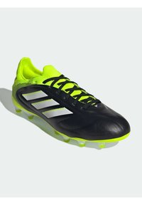 Zwarte voetbalschoenen met neon groene accenten, bovenwerk van textuurleer, drie witte strepen, zwarte veters en gemolde noppen.