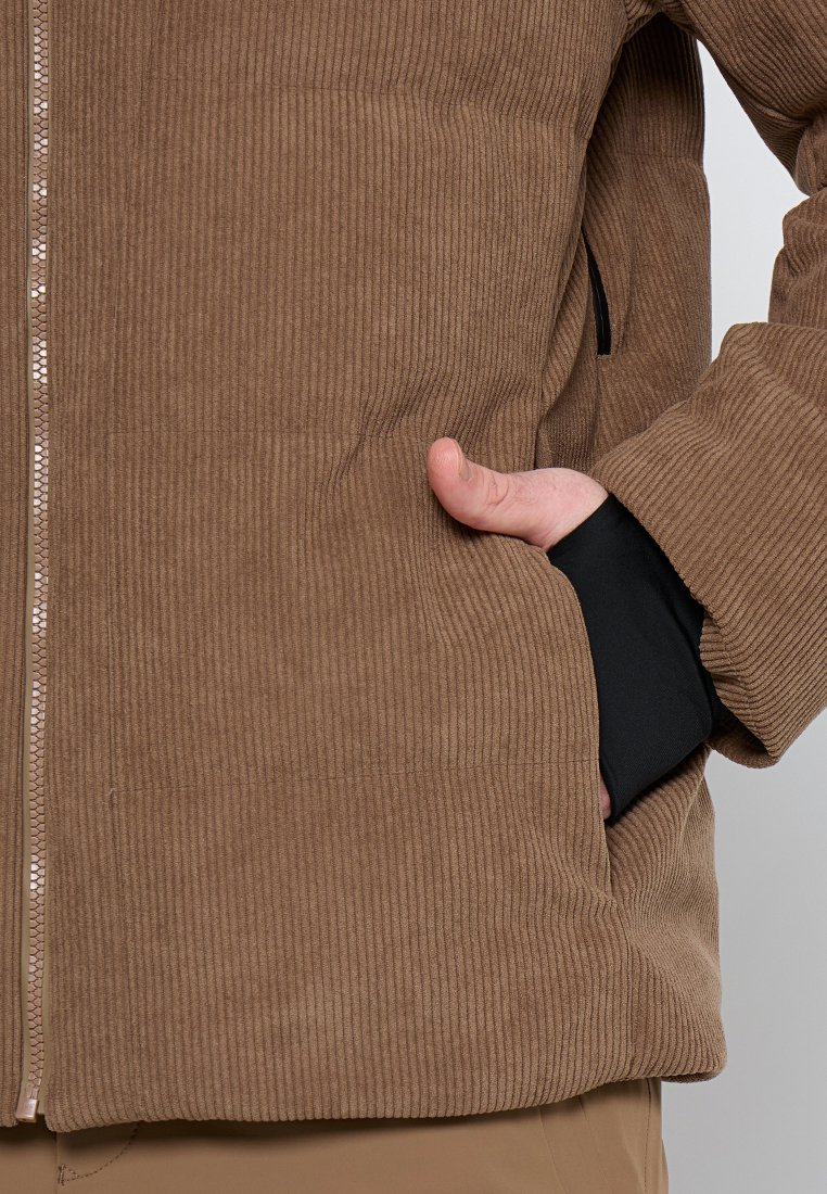 Braune Cordjacke mit gerippter Textur, Frontreißverschluss, schwarzen Innenbunden und Seitentaschen. Einfaches Design mit dezenten Nähedetails.