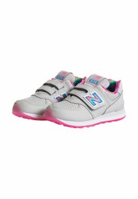 Sneaker grigia con accenti rosa, fascia in velcro, parte superiore testurizzata, perforazioni per traspirabilità e fodera interna colorata.