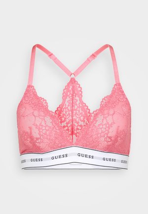 Pink lace bralette featuring a plunging neckline, crisscross straps, and a white elastic band with "GUESS" printed in black.