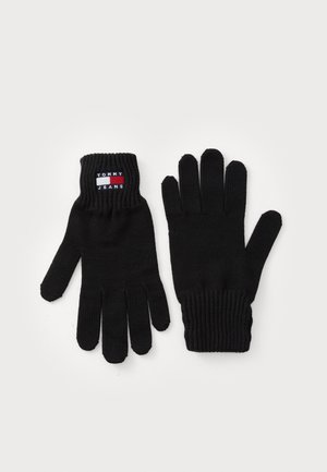 Gants tricotés noirs avec des poignets côtelés, comportant une étiquette logo Tommy Jeans au niveau du poignet. Tissu résistant et design à cinq doigts.