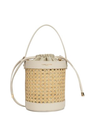 Sac seau rond en osier tressé naturel avec une base en cuir beige et une fermeture à cordon. Accents en métal doré.