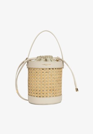 Borsa a secchiello rotonda in canna intrecciata naturale con base in pelle beige e chiusura a cordoncino. Dettagli in metallo dorato.