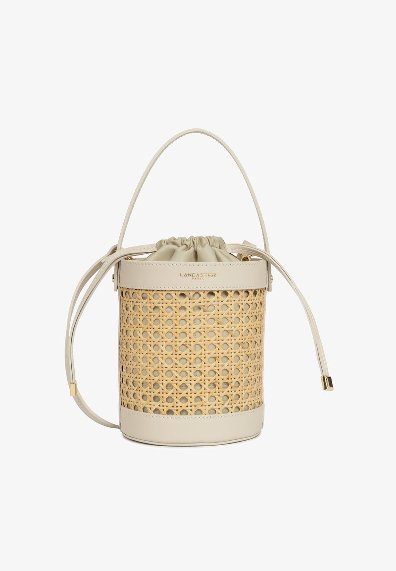 Borsa a secchiello rotonda in canna intrecciata naturale con base in pelle beige e chiusura a cordoncino. Dettagli in metallo dorato.