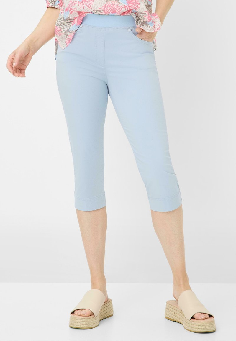 Pantalons capri bleu clair en tissu doux, avec une taille lisse et deux poches latérales, ourlet retroussé et détails de couture subtils.