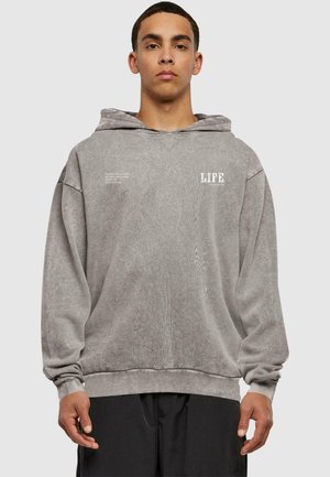 Grå hættetrøje med løs pasform, tekstureret stof og hvidt trykt tekst "LIFE" på brystet. Ribbestrikkede manchetter og kant.
