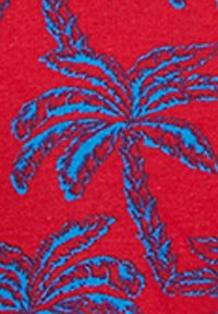 Blue palm tree pattern on bright red textured fabric background, showing leaf details and trunk outlines.