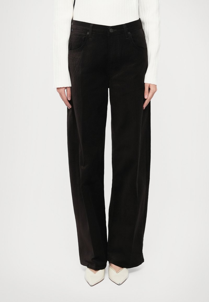 Pantaloni largi din catifea neagră cu talie înaltă, având buzunare frontale, o închidere cu un singur nasture și un finisaj texturat subtil.