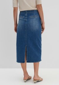 Jupe midi en denim bleu foncé avec une fente à l'arrière, deux poches arrière et une taille classique. Texture lisse et silhouette ajustée.