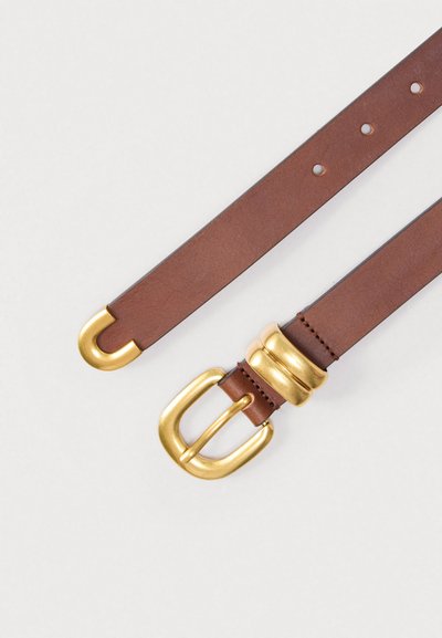 Καφέ δερμάτινη ζώνη με λεία υφή, που έχει αγκράφα από χρυσό μέταλλο με διπλό βρόχο και τρεις ανυψωμένες λεπτομέρειες κοντά στην αγκράφα.