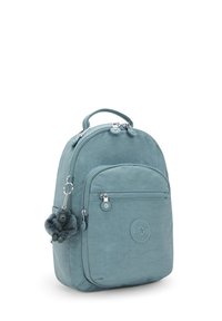 Piccolo zaino blu-verde con tasca frontale con zip, manico superiore, doppie zip e portachiavi a forma di scimmia in peluche attaccato alla zip laterale.