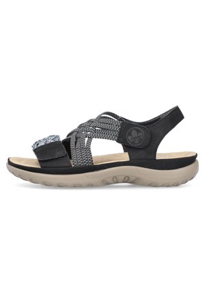 Zwarte sandaal met gevlochten elastische bandjes, een stoffen accent, een gevoerd inlegzool en een gevormde tan rubberen zool, ontworpen voor comfort en ondersteuning.