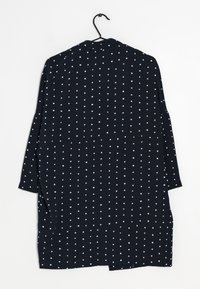 Laivastonsininen vaate, jossa on väljä muotoilu ja vaaleansinisin pistein kuvioitu kangas. Kangas näyttää kevytpainoiselta ja sileältä.