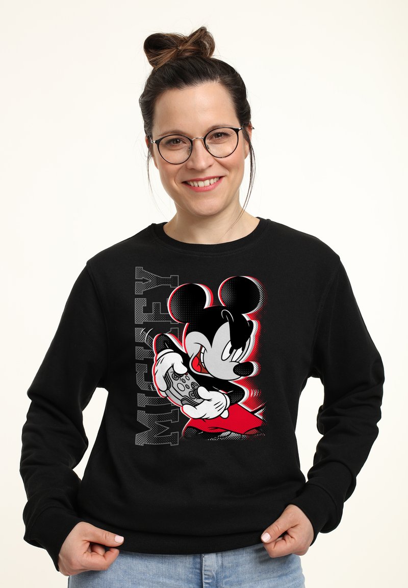 Sudadera negra con un gráfico de Mickey Mouse sosteniendo un controlador de videojuegos, con acentos en rojo y gris y el texto "MICKEY" en letras negritas.
