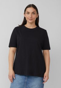 Schwarzes Baumwoll-T-Shirt mit kurzen Ärmeln und rundem Ausschnitt. Hat eine lässige Passform, eine glatte Textur und keine sichtbaren Muster oder Designs.