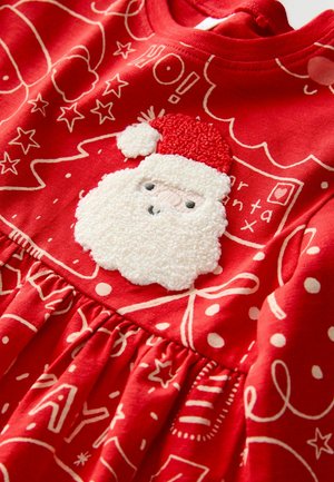 Rotes Baumwollkleid mit einem strukturierten weißen Santa-Gesicht mit rotem Hut, vor einem Hintergrund aus weißen festlichen Designs und Mustern.