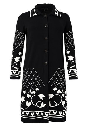 Lang sort cardigan med detaljerede hvide blomster- og geometriske mønstre, med kraveudskæring og knaplukning foran.