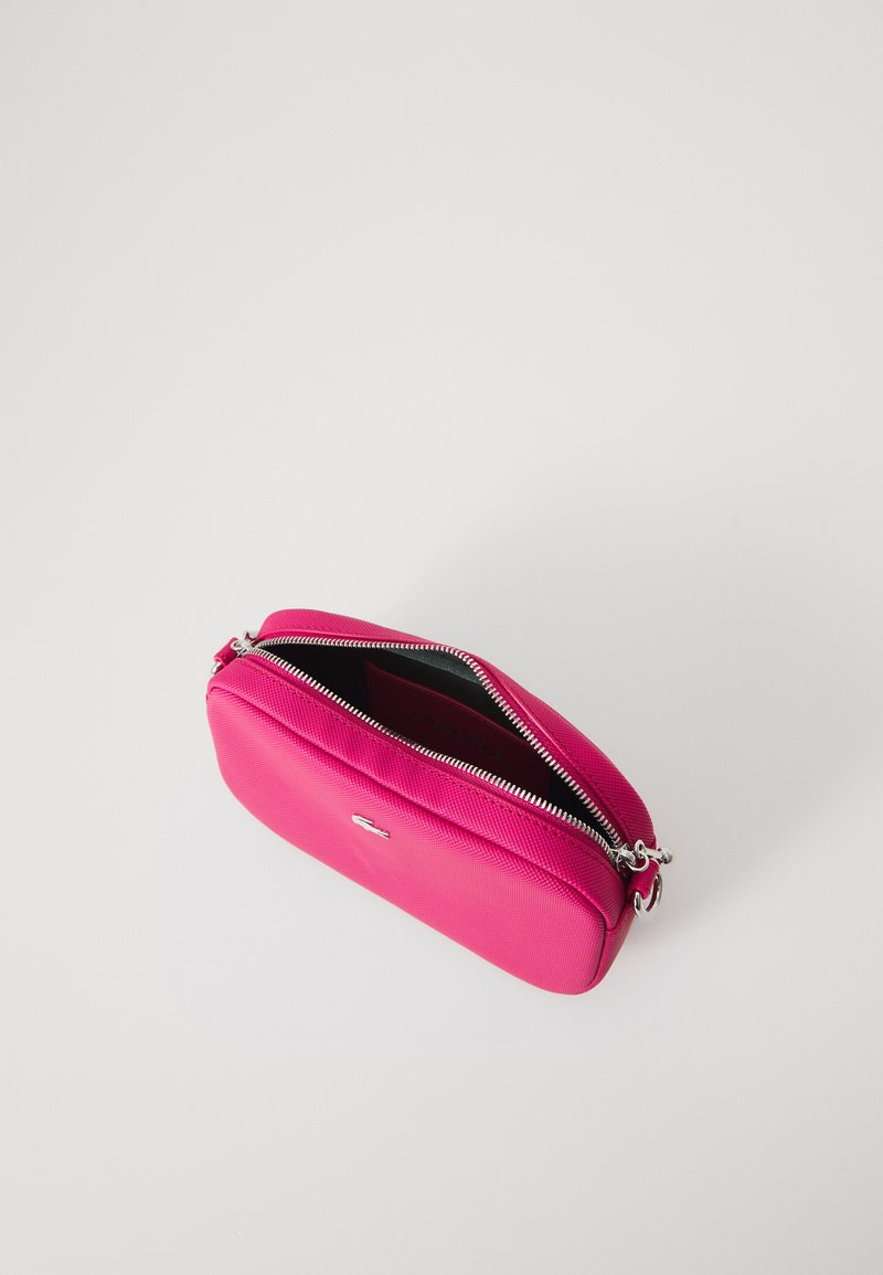 Roze met rits afgewerkte tas van textuur materiaal, met een zilveren rits en subtiele logo-details, met een ruime binnenkant.