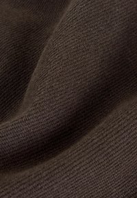 Pruunist kootud kangast pehme tekstuuriga, esitledes herringbone mustrit. Pind paistab siledana ja veidi läikivana.