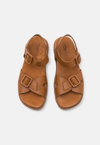 Sandali in cuoio marrone con cinturini regolabili, fibbie quadrate e una soletta in suede testurizzato. Ideali per un abbigliamento casual.