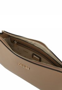 Clutch textured color tan con zip e logo Guess dorato, con tasca interna con zip, che mostra una fodera in tessuto beige con stampa del logo.