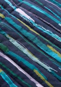 Tkanina bawełniana z pionowymi paskami w kolorze teal, zielonym i szarym na ciemnym tle. Posiada teksturowaną powierzchnię i nieregularne wzory.