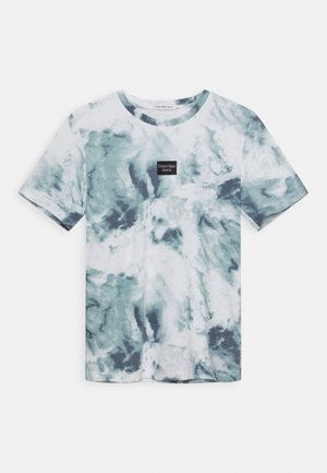 Koszulka z krótkim rękawem, z dekoltem okrągłym, w niebiesko-biały wzór tie-dye oraz małym czarnym logo Calvin Klein Jeans umieszczonym na środku klatki piersiowej.