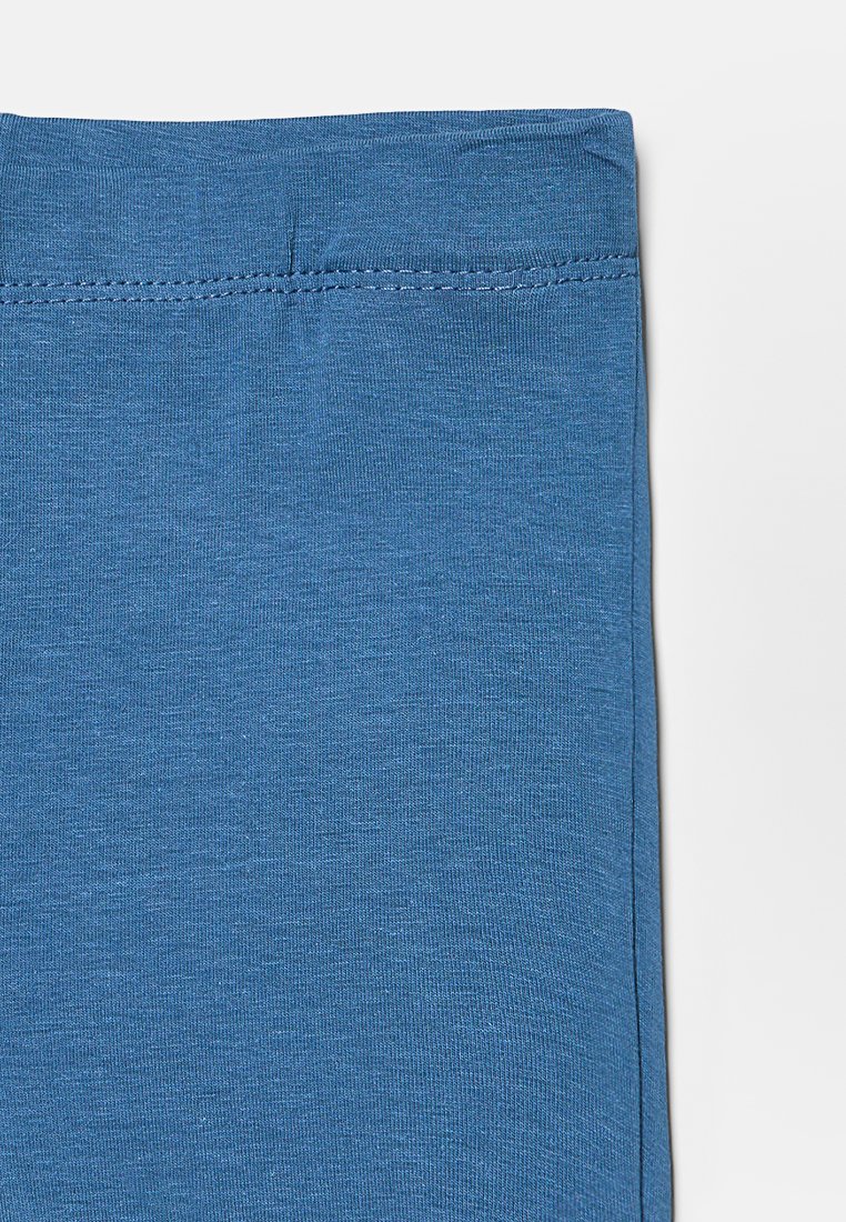 Tissu en coton bleu avec une texture lisse et un léger élasticité. Design simple avec une taille élastique et des coutures plates, sans détails supplémentaires.