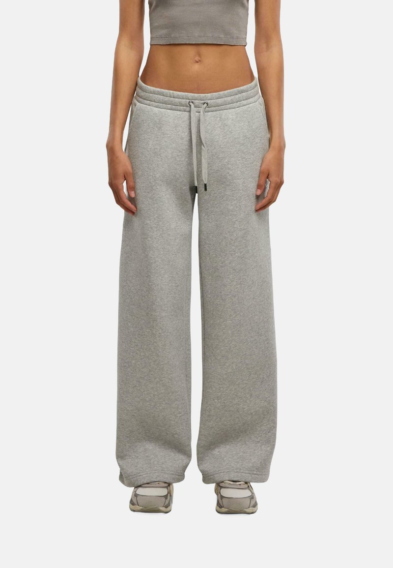 Pantaloni da tuta grigi chiari a gamba larga realizzati in morbida miscela di cotone, caratterizzati da una vita elastica con cordino e tasche laterali.