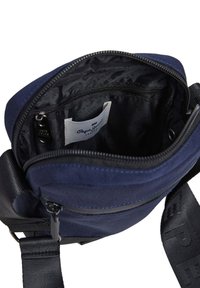 Jūras spēku zilas krāsas plecu soma ar rāvējslēdzēju. Iekšpusē ir melns odere, etiķete un neliela kabata. Iekļauta regulējamā siksna.