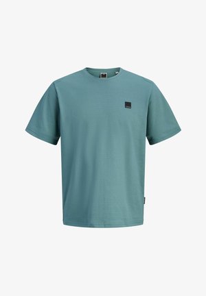 Meeste lühikese varrukaga ümar kaelusega T-särk tuhmikas toonerohkes värvitoonis, tekstuurse kangaga ja väikese musta ruudukujulise logoga vasakul rinnal.