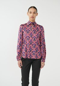Langemouwen blouse met hoge kraag, met een geometrisch patroon in roze, paars en beige. Textuurstof met geplooide manchetten.