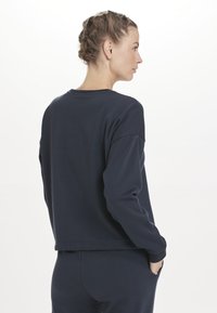 Marine sweatshirt met lange mouwen, een relaxte pasvorm, ronde halslijn en een zoom die op de taille valt. Zacht stof zonder patronen of versieringen.