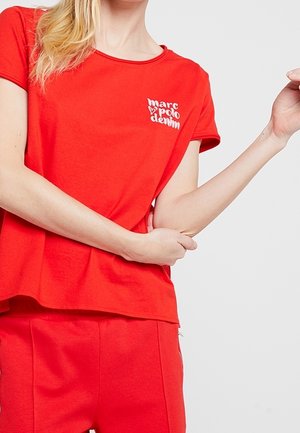 Rood katoenen T-shirt met een ronde hals en korte mouwen, voorzien van een wit gedrukt logo op de linkerborst.