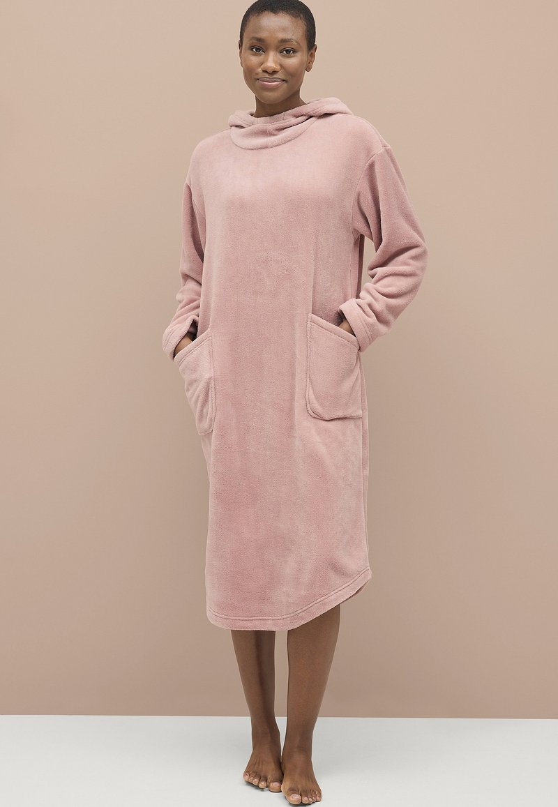 Rosa fleece hættekjole med lange ærmer, to frontlommer og en afslappet pasform, der har en blød tekstur og en mellemlang design.