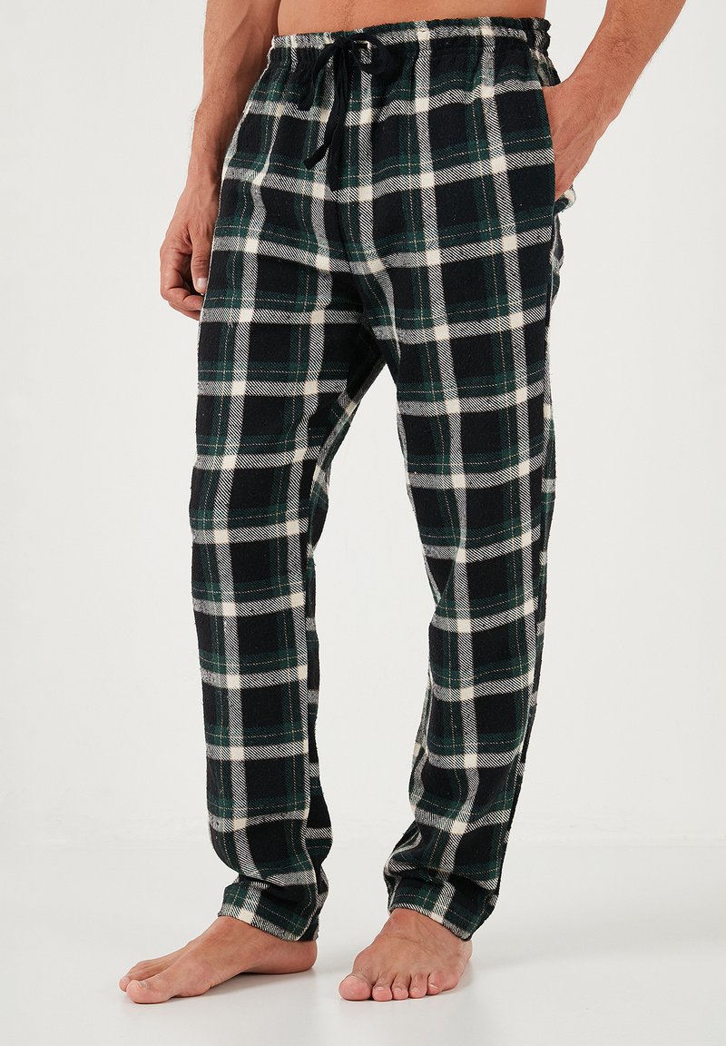 Flanellen pyjamabroek in een zwart, groen en wit geblokt patroon. Voorzien van een trekkoord in de taille en een ontspannen pasvorm met een zachte textuur.
