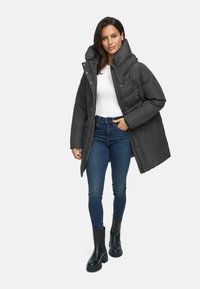 Gray padded coat with high collar, zip and snap fastenings, worn over a white top. Paired with blue jeans and black ankle boots.