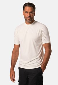 Hvid kortærmet T-shirt lavet af letvægtigt materiale, med rund hals og slim fit. Båret med sorte cargo shorts.