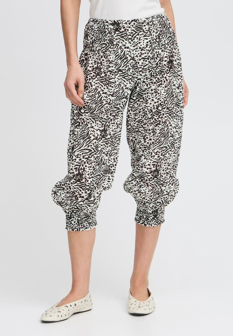 Pantaloni cropped a scacchi in bianco e nero con vita elastica e polsini arricciati. Il tessuto è leggero e presenta una finitura testurizzata.