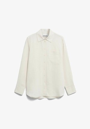 Chemise à manches longues de couleur crème, boutonnée, avec col et poche poitrine, étalée à plat sur un fond blanc.