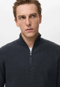 Maglione girocollo grigio scuro a coste con collare a mezza zip, realizzato in un morbido tessuto testurizzato, caratterizzato da un design minimalista e dettagli in zip argentata.