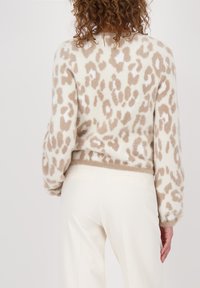 Leopardmuster Pulli aus weichem Material in Creme und Beige, mit lässigem Schnitt, langen Ärmeln und elastischem Saum. Einfacher, strukturierter Stoff.