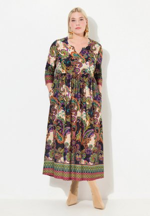 Langes, gemustertes Kleid mit tiefem V-Ausschnitt, Dreiviertelärmeln und Taschen. Es zeichnet sich durch bunte Paisley- und Blumenmuster auf einem dunklen Grund aus.