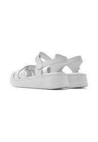 Witte sandalen met een strapontwerp, voorzien van ronde uitsparingen, een gestructureerde zool en een gevoerde platform voor extra comfort.
