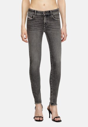 Jean skinny gris en denim avec une texture délavée, présentant une taille mi-haute, cinq poches et des détails de couture subtils.