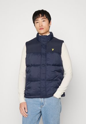 Gilet imbottito blu navy con colletto alto e chiusura a zip, caratterizzato da un materiale texture sulla parte superiore e un logo ricamato giallo sul petto.