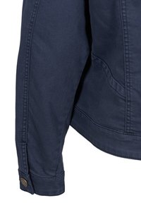 Manga de chaqueta de algodón azul marino con costuras visibles, detalle de botón en el puño y una textura suave; diseño angular con estilo minimalista.