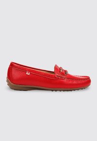 Mocasín de cuero rojo con suela de goma marrón, detalle metálico en la parte superior y pequeña etiqueta de tela con logo en el lateral, mostrado de perfil.